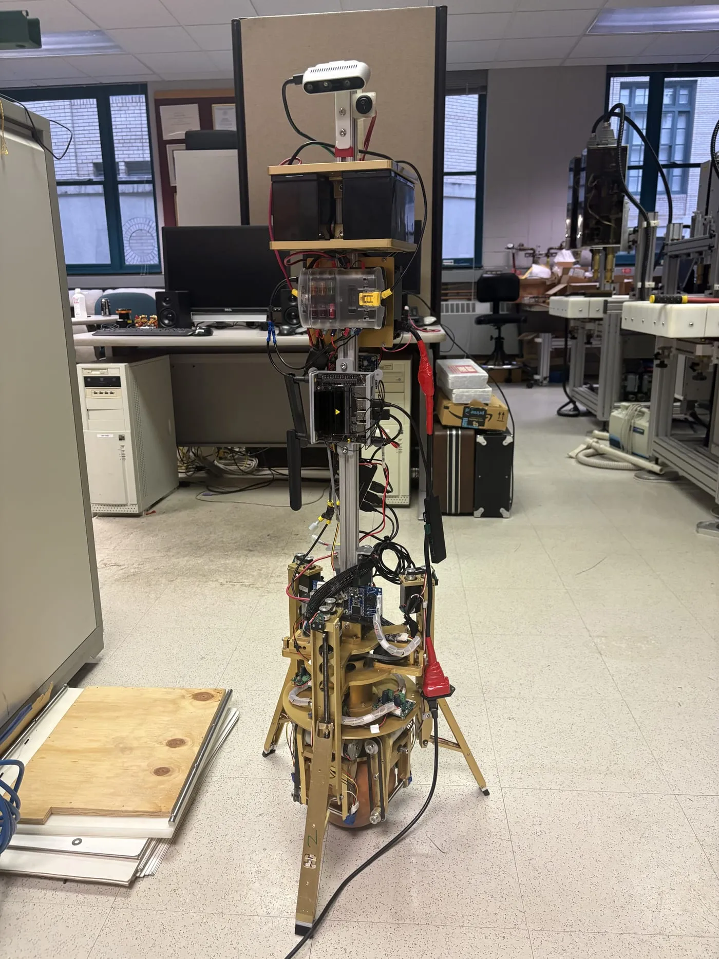 The Shmoobot ballbot standing in the lab: a tall mast on a ball drive, with batteries, a compute module and a depth camera at the top